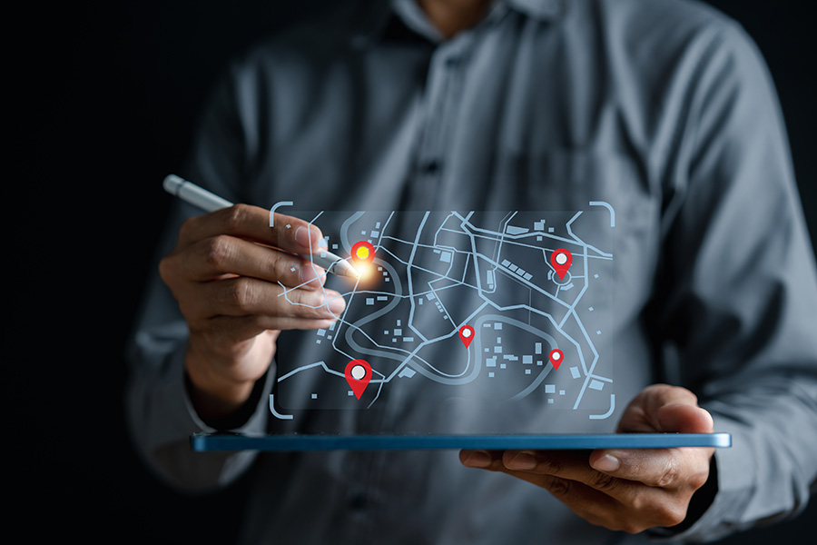 close up of an individual navigating a virtual map projecting from a tablet